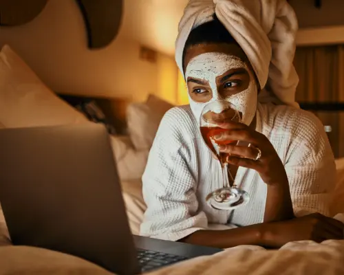 girl enjoying glass of wine and face mask